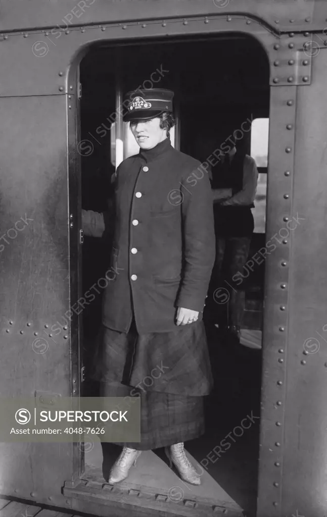 Uniformed woman Brooklyn Subway guard stands in the doorway of train car. Ca. 1910.