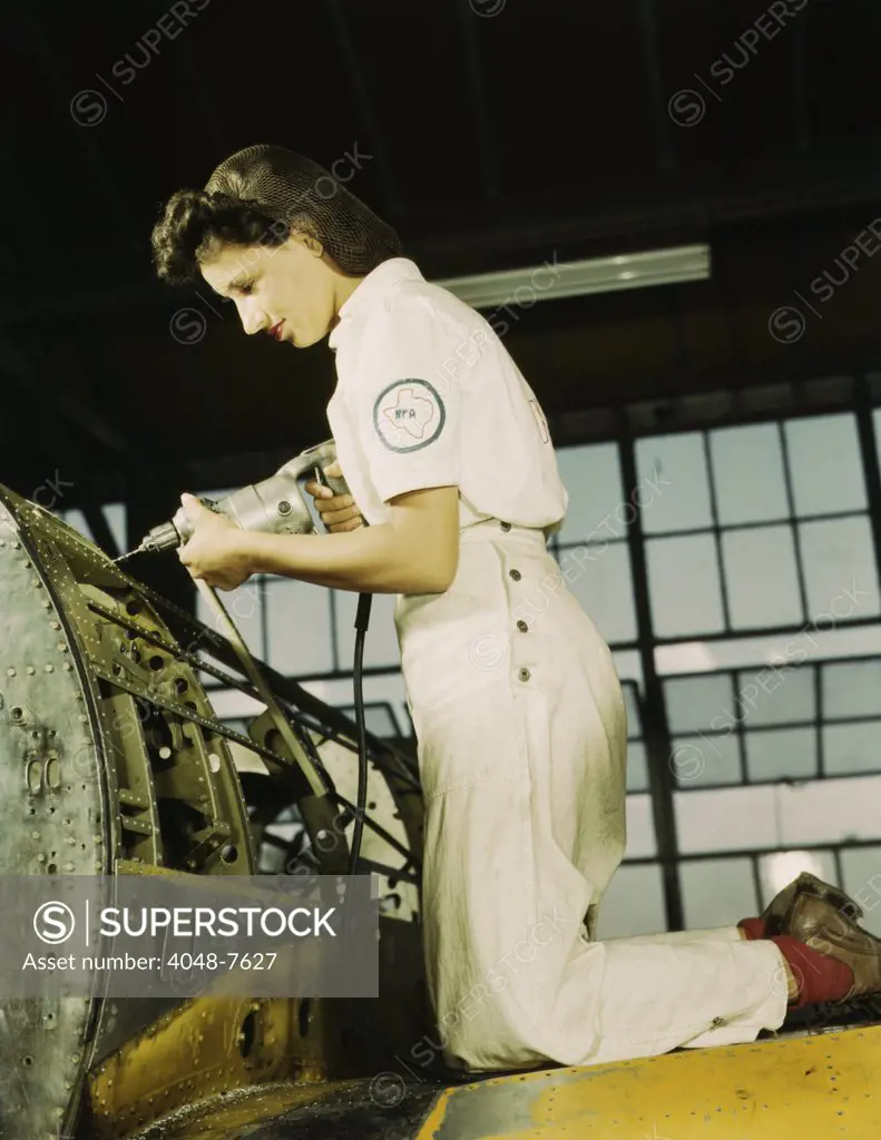 Defense worker riveting as part of her training to become a mechanic at the Naval Air Base, in Corpus Christi, Texas. August 1942.