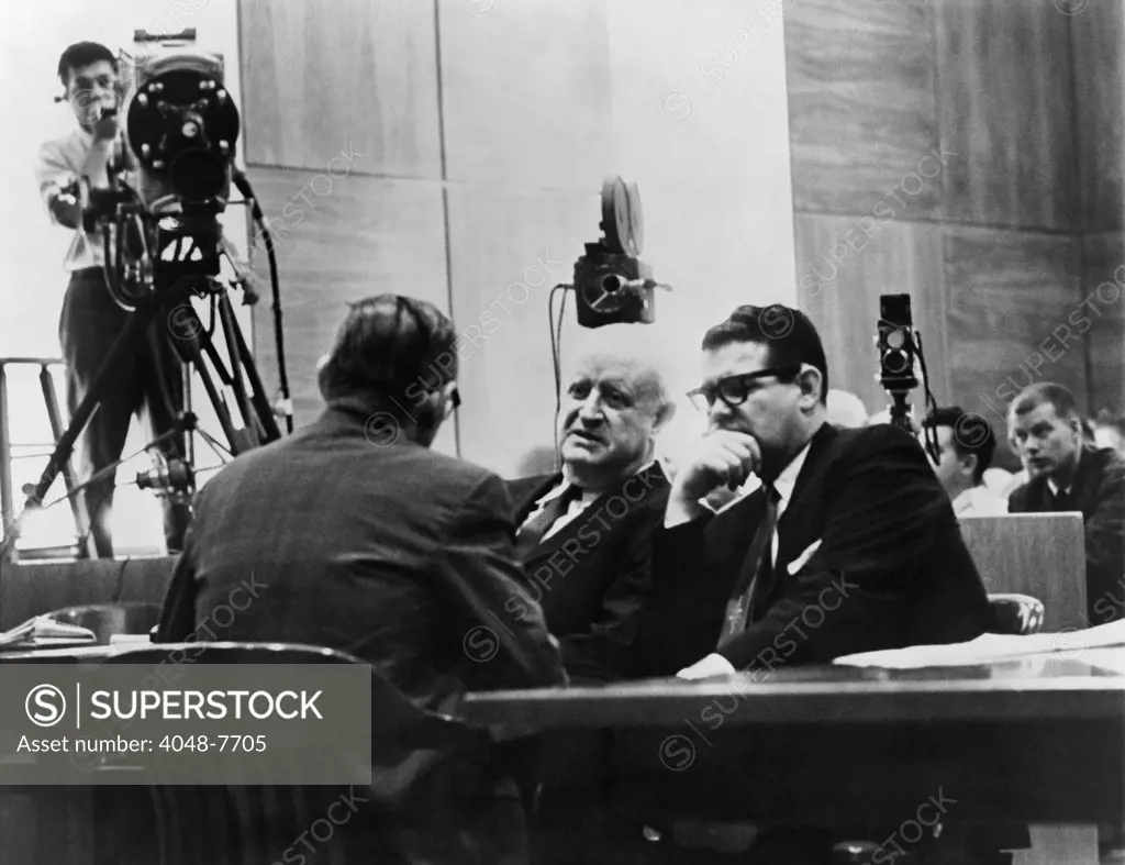 Television cameras filming Billie Sol Estes right conferring with his attorneys during his fraud trial for receiving millions of agricultural subsidies. The highly connected Texas Democrat successfully argued that camera coverage of the trial deprived