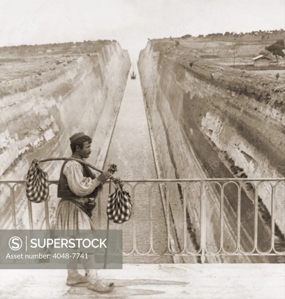 Greek man in traditional costume on a bridge over the Corinth Canal built between 1881 and 1893. Cut through sedimentary rock it connects the Gulf of Corinth Adriatic Sea and the Saronic Gulf Aegean Sea and is 3.9 miles long and 79 feet wide. LC-USZ62-66141