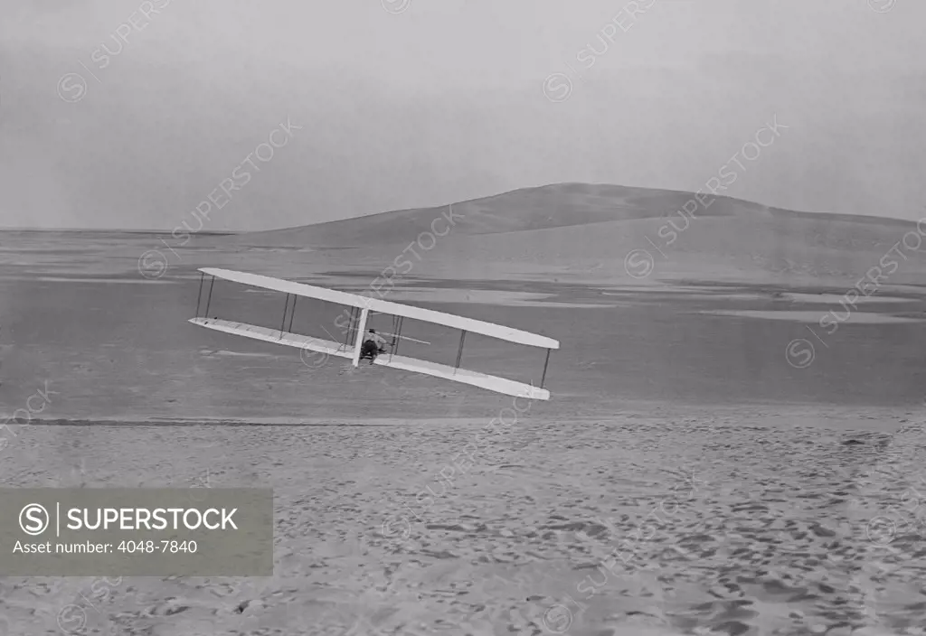 Wilbur Wright 1867-1912 making a right turn in a glider at Kitty Hawk North Carolina. October 24 1902. The Wright Brothers learned to control the kites and gliders for three years before their first powered flight on December 17 1903. LC-DIG-ppprs-00598
