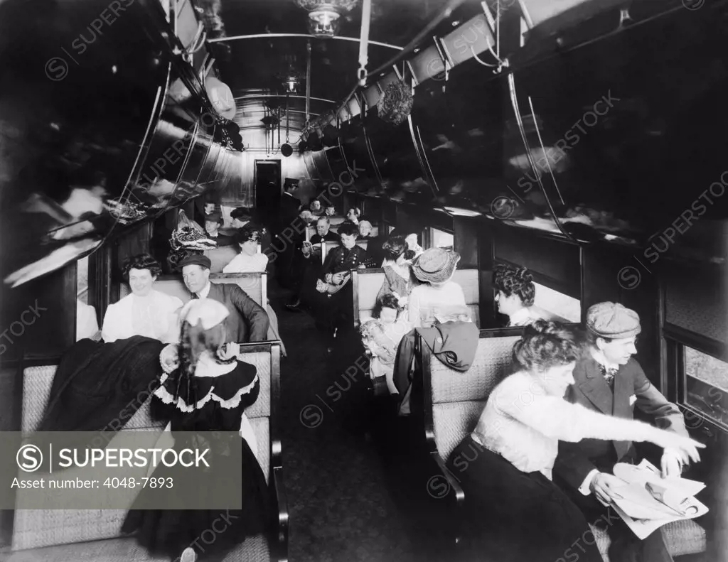 Passengers in an American Pullman railroad car in 1905. At the car's rear are two African American Pullman porters