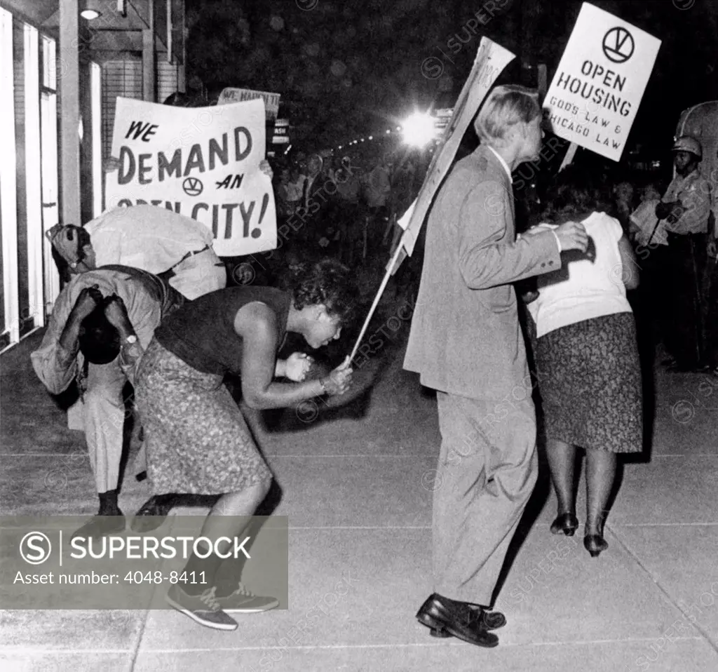 Open Housing demonstrators attacked in Chicago. Civil Rights marchers duck to avoid flying rocks and firecrackers hurled at them while they protested housing practices of real estate offices in an all white neighborhood. Aug. 16, 1966.
