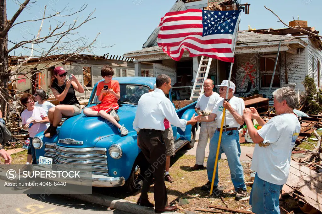 President Barack Obama greets Hugh Hills, 85, in front of his home in Joplin, Mo. following a devastating series of tornados. May 29, 2011