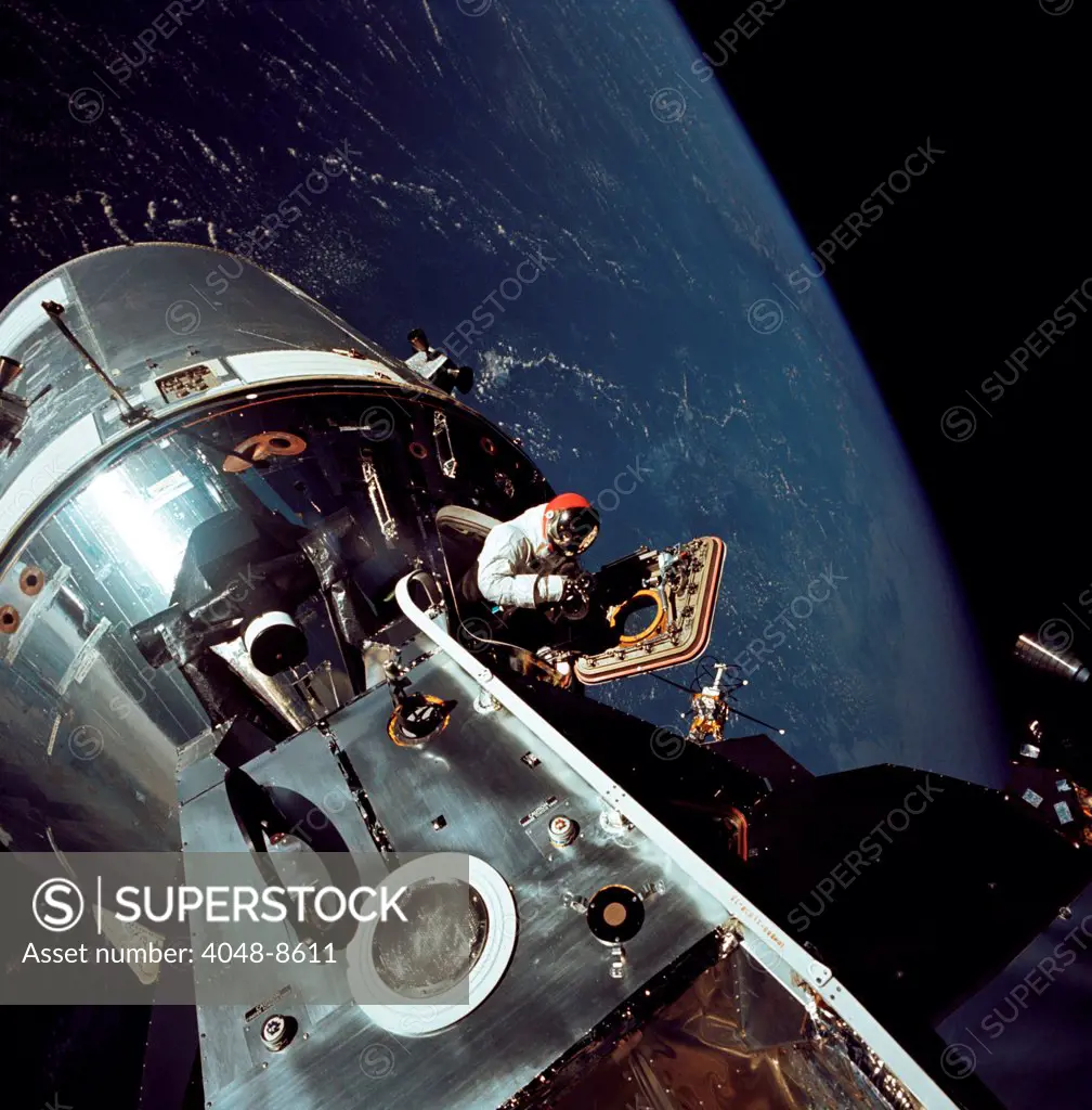 Apollo 9 astronaut Dave Scott stands in the open hatch of the Command Module, docked to the Lunar Module in Earth orbit. Apollo 9 tested the orbital rendezvous and docking procedures that made the lunar landings possible. March 6, 1969.