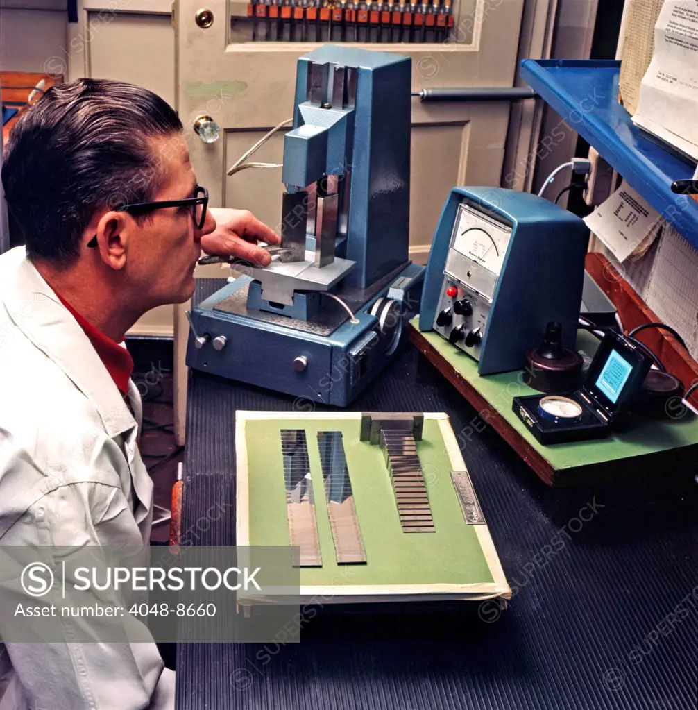 Instrumentation engineer examines the properties of metals to be used in Ford cars. Ford Motor Company, Dearborn, Michigan, 1966. Photo: John G. Zimmerman Archive/Courtesy Everett Collection