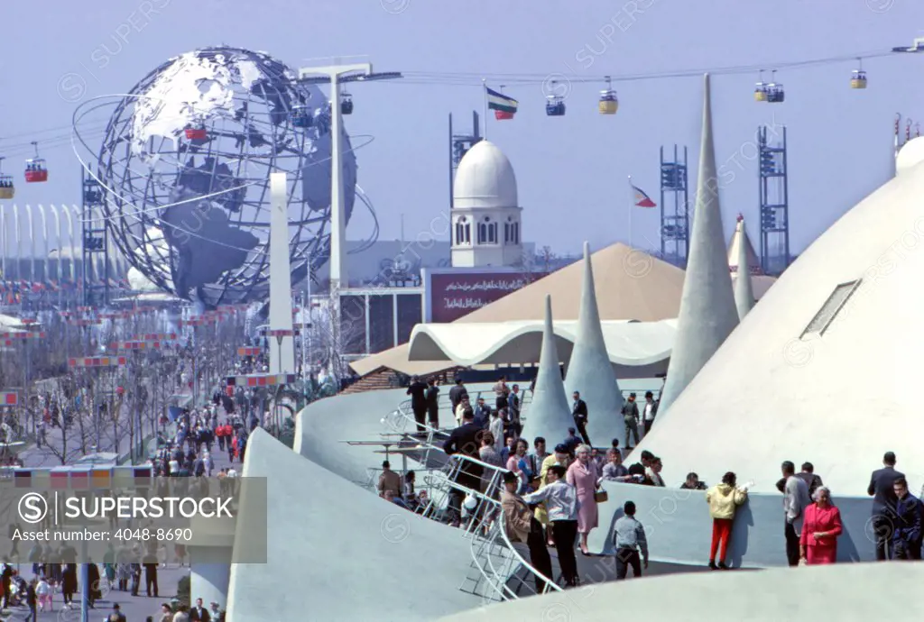 1964 World's Fair, Flushing Meadows, New York. Visitors to the Jordanian Pavillion enjoy the views from the terrace of the multi-peaked-and-domed structure, one of the Fair's most striking buildings. The dome of the Sudanese pavilion and Unisphere are behind.