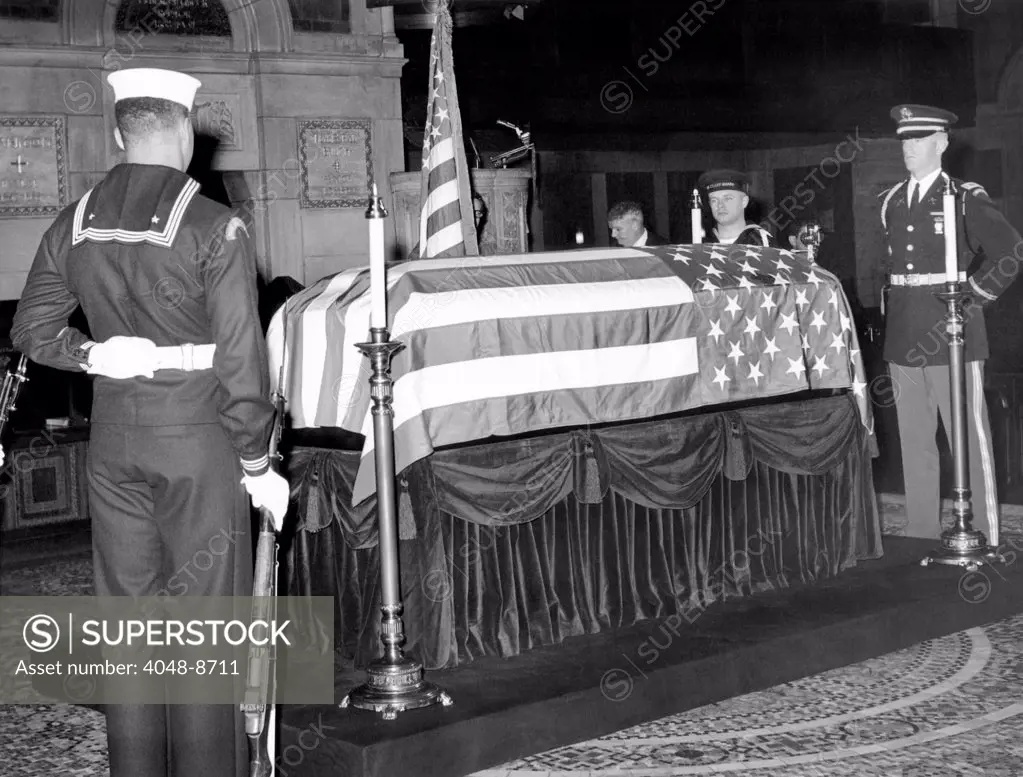 Former President Herbert Hoover's flag draped coffin. Armed force honor guards surround the casket in St. Bartholomew's Church, New York City, Oct. 21 1964.