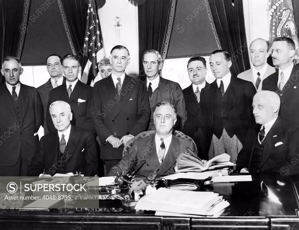 President Franklin Roosevelt with preparing for the 1933 World Economic Conference. Seated, L-R: Cordell Hull, Secy. Of State, FDR, Guido Jung, Italian Minister of Finance. Standing, L-R: Raymond Moley, James Warburg, Rexford Tugwell, Sen. Key Pittman, Breckinridge Long, Giuseppe Del Vecchio, Augusto Rosso, Italian Ambassador, William Bullit, and Eugenio Anzilotti. May 3, 1933.
