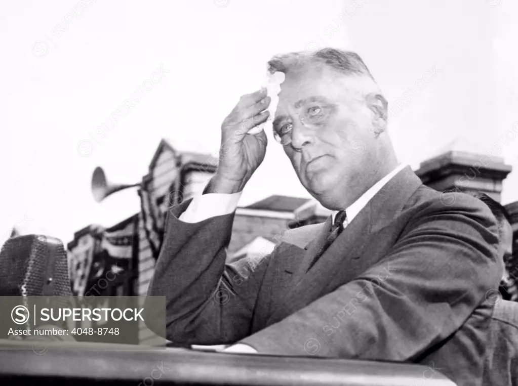 President Franklin Roosevelt mopping his brow during a 'purge speech'. He was extolling the virtues of Rep. David J. Lewis, the Democratic Primary opponent of incumbent Senator Millard Tydings. Tydings was a target of FDR's 1938 'purge' of Democrats who opposed the New Deal. Maryland, Denton, Sept. 5, 1938.