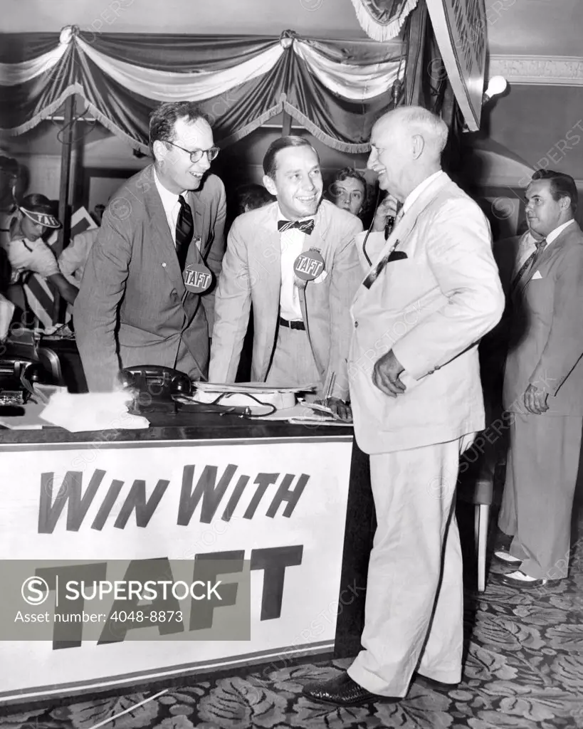 Senator Robert Taft's two sons promote their father's GOP Presidential nomination. At Taft headquarters in the Conrad Hilton hotel, William Howard Taft, 36, and Lloyd Taft, 29 chat with Delegate Myers Y. Cooper, former governor of Ohio. July 5, 1952.