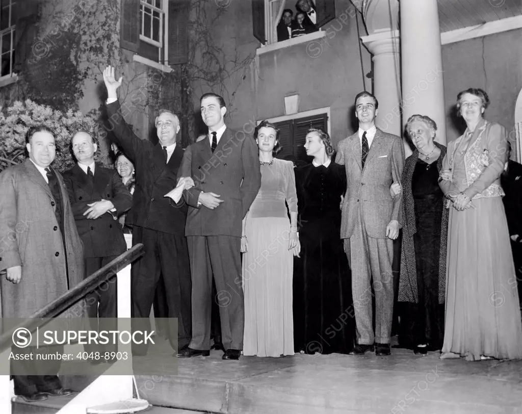 With friends and his family President Franklin Roosevelt waves to his Dutchess County neighbors, after it was certain he won election to his third term. L-R from President Roosevelt: Franklin D. Roosevelt Jr., Mrs. John Roosevelt, John Roosevelt, Mrs. Sara Delano Roosevelt, and Mrs. Eleanor Roosevelt, the First Lady. Nov. 6, 1940.