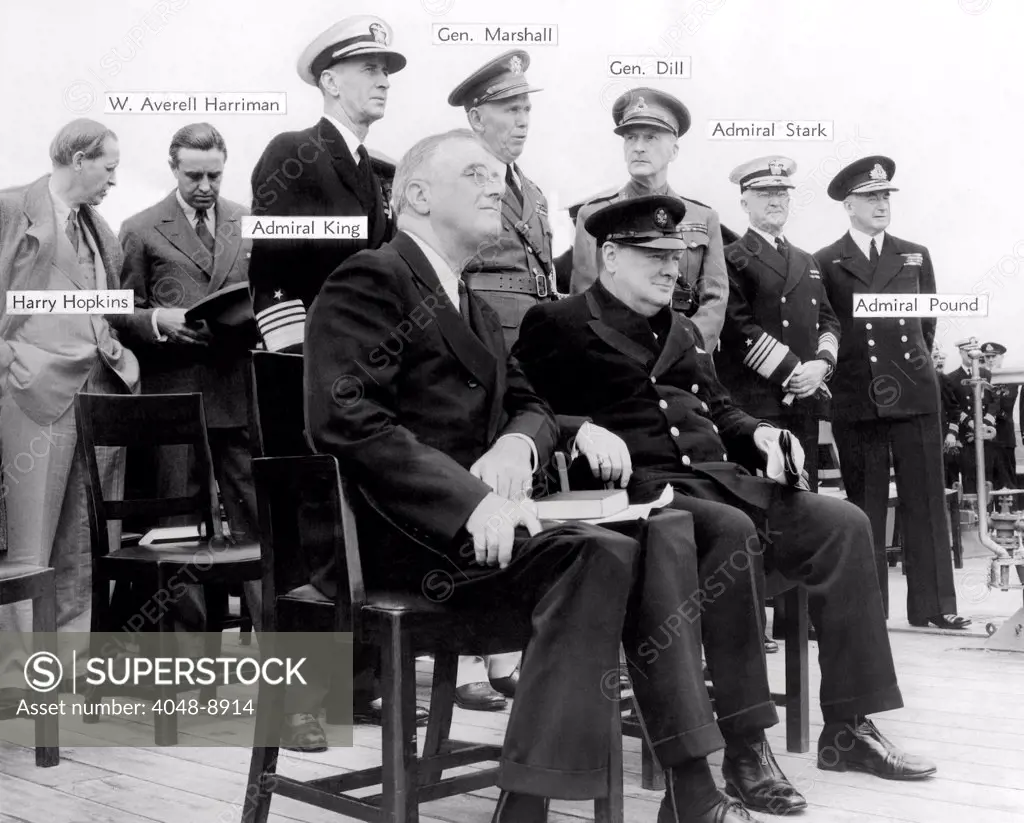 The Atlantic Conference. Franklin Roosevelt and Churchill with their chief advisors aboard H.M.S. Prince of Wales on Aug. 12, 1941. Standing, L-R: Harry Hopkins, Averell Harriman, Lend-Lease Coordinator, Adm. E. J. King, U.S. Navy, Gen. George Marshall, US Army, Gen. Dill, British Navy, Adm. Harold Stark, US Navy, and Adm. Sir Dudley Pound, British Navy.