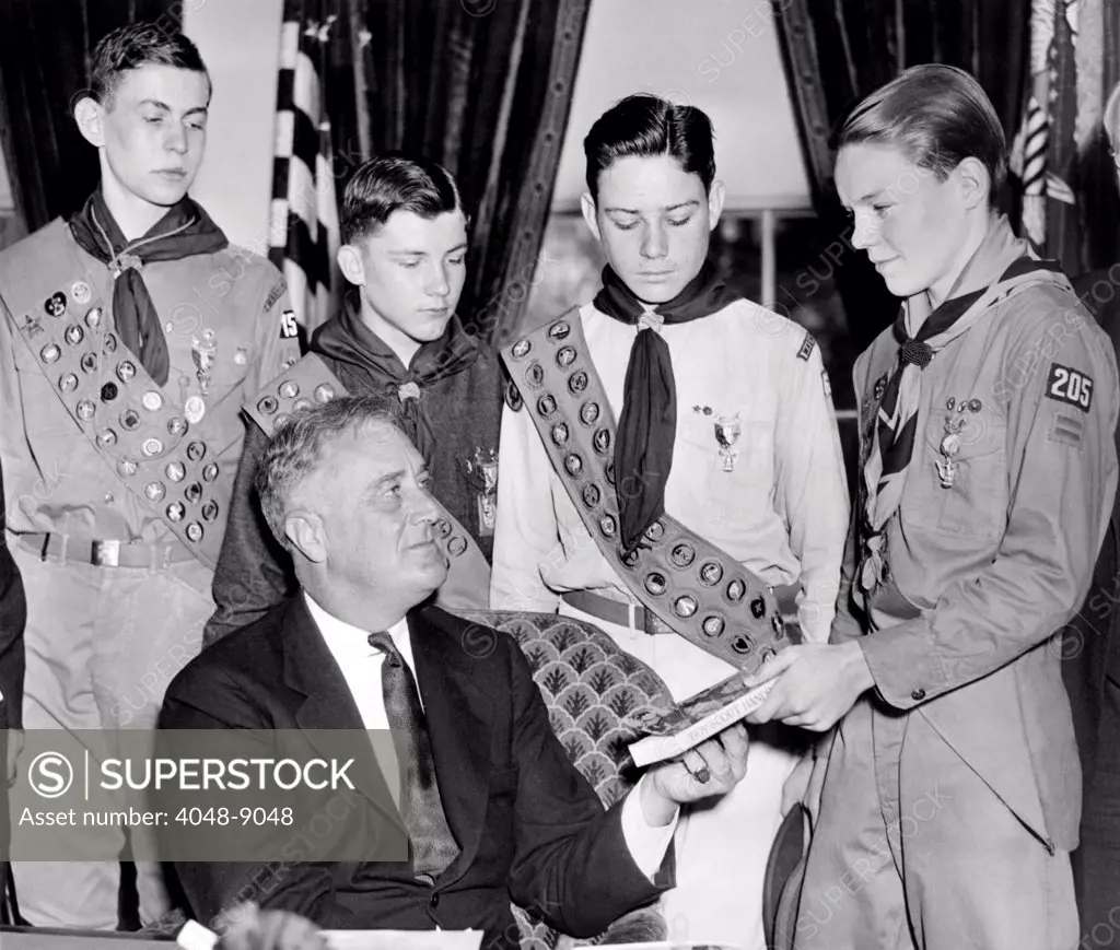 President Franklin Roosevelt receives the five-millionth copy of the Boy Scout Handbook. Eagle Scouts presented the special silver and green bound book to FDR on April 13, 1935.
