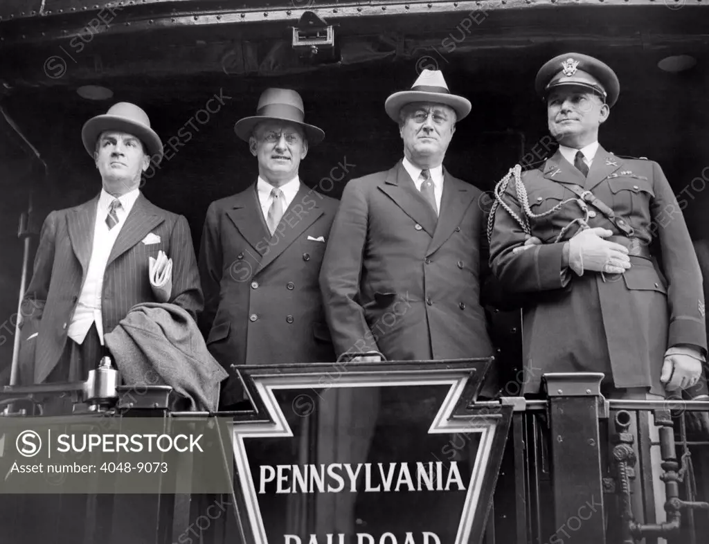 President Franklin Roosevelt observes Memorial Day. FDR posed for photographers on the back of his train to Gettysburg, where he will make a Memorial Day speech. L-R: Warren Robbins, American Minister to Canada, Henry Morgenthau Jr., Secy. Of the Treasury, President Roosevelt, and Colonel Edwin Watson, White House Military aide. April 30, 1934.