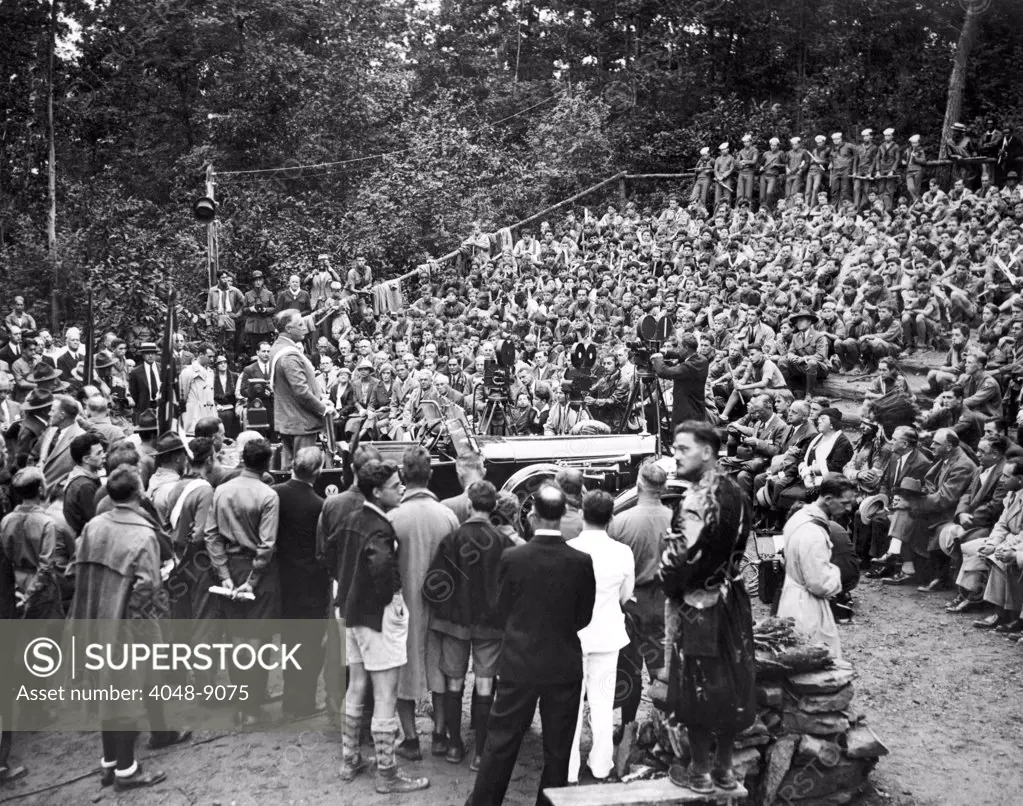 President Franklin Roosevelt addresses the Boy Scouts. FDR stands in his car while speaking to more than 2,500 New York City Boy Scouts at the ten-mile camp at Narrowsburg, NY. Aug. 23, 1933.