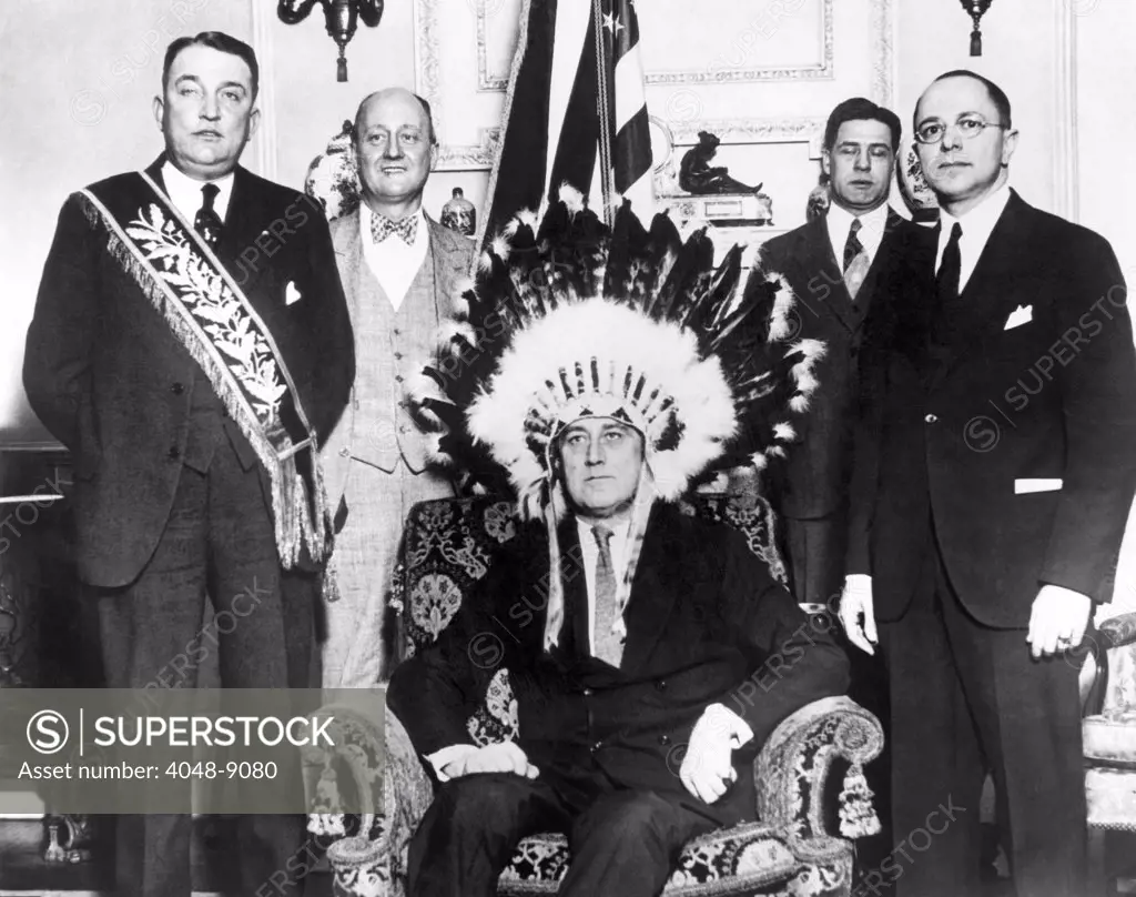 Governor Franklin Roosevelt made a member of the Fraternal Order of Red Men. The order was inspired by the Indian costumes worn by the patriots at the Boston Tea Party. Jan. 1930. L-R: Judge Harry Cathriell, national head of the Red Men, Gilbert Orrin Townsend, Gov. Roosevelt, Guernsey Cross, Governor's secretary, and Louis Butler.