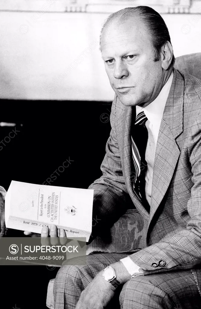 President Gerald Ford holds the Official Report of the Rockefeller Commission's investigation of the CIA. It revealed abuses including mail opening, surveillance of domestic dissident groups, and Project MKULTRA, a CIA mind control study. June 6, 1975.