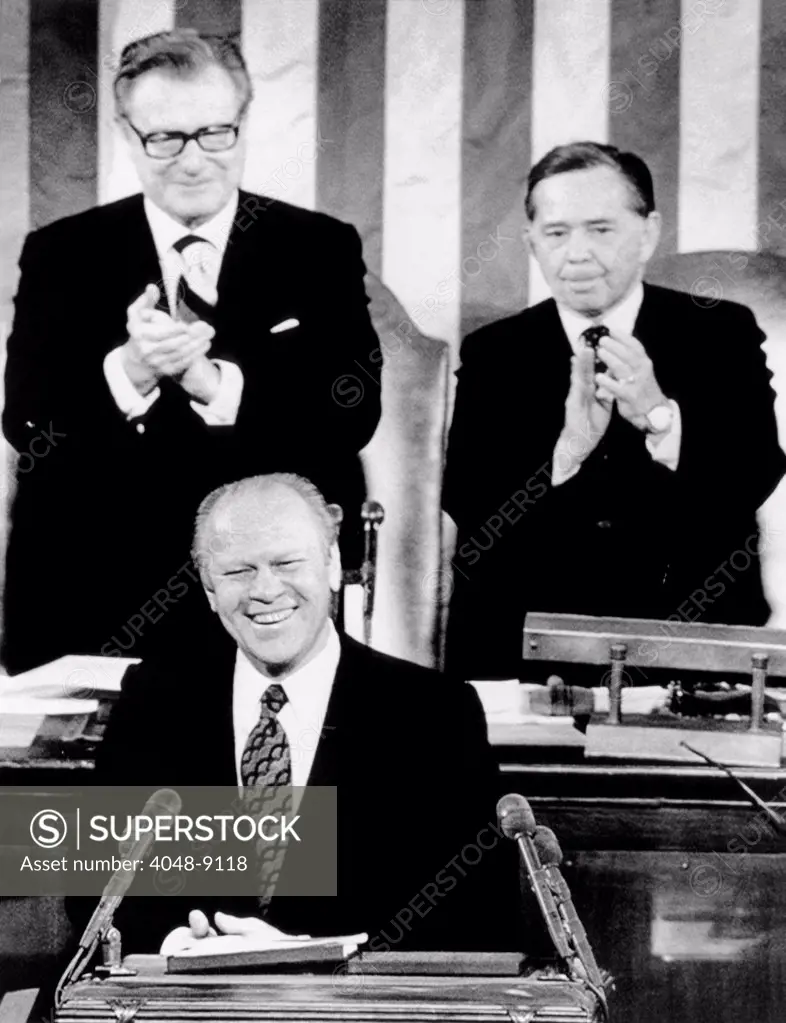 President Ford delivers his first State of the Union address. He discussed the national debt, taxes, the federal budget and the energy crisis. He proposed tax cuts to fight the current recession. Behind Ford are Vice President Nelson Rockefeller and House Speaker Carl Albert. Jan 15, 1975.