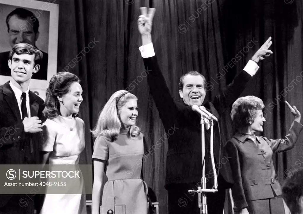 New President-elect Richard Nixon strikes a victorious pose on election night. Nixon won 43.4% to 42.7% won by Hubert Humphrey. L-R: David Eisenhower, Julie's fiancé, Julie Nixon, Tricia Nixon, Richard Nixon, Pat Nixon.