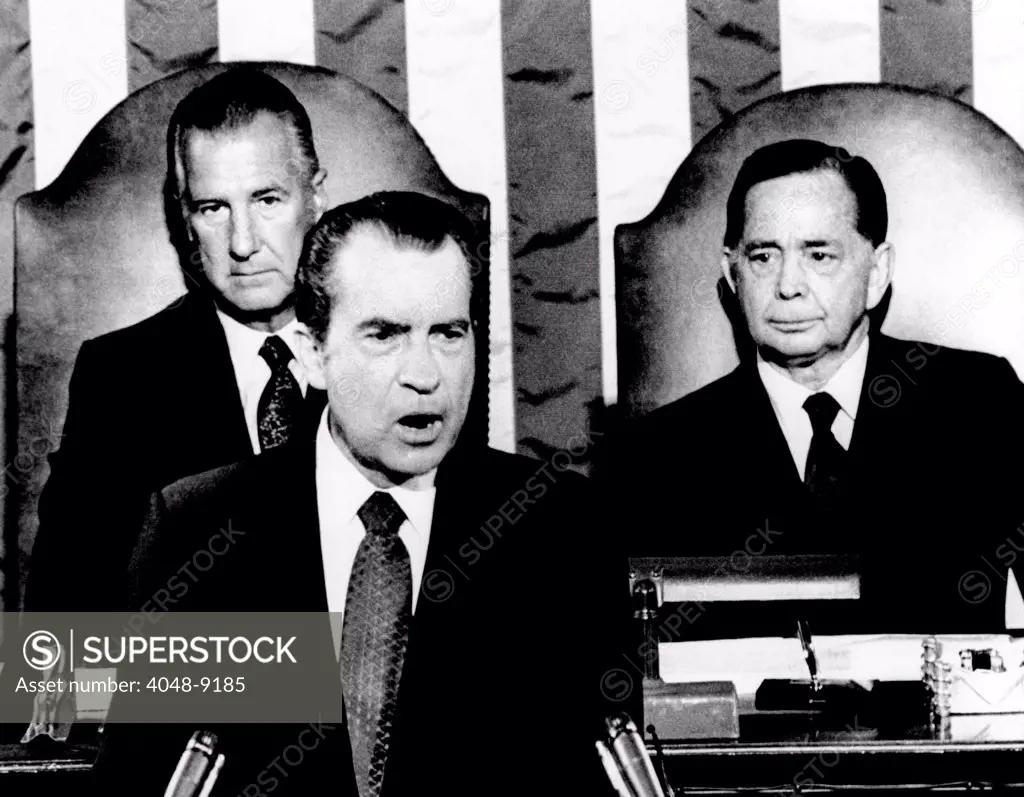 Addressing Congress, President Richard Nixon announces a 90-day wage-rent freeze to be started on August 15, 1971, would not be extended. Behind him are Vice Pres. Spiro Agnew (left) and House speaker Carl Albert. Sept. 9, 1971.
