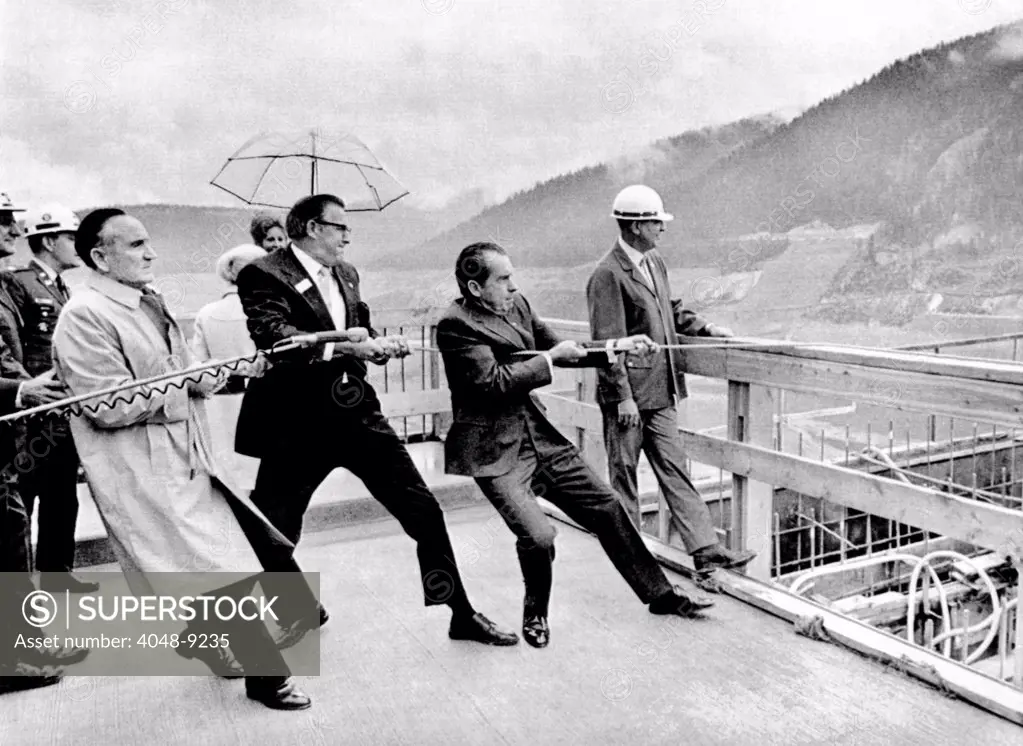 Dam building ceremony in Montana. President Richard Nixon helps Sen. Mike Mansfield, and Rep. Dick Shoup, drop the 3,000,500th cubic yard of concrete into the Libby Dam which is under construction in Kalispell, Montana. Sept, 25, 1971.