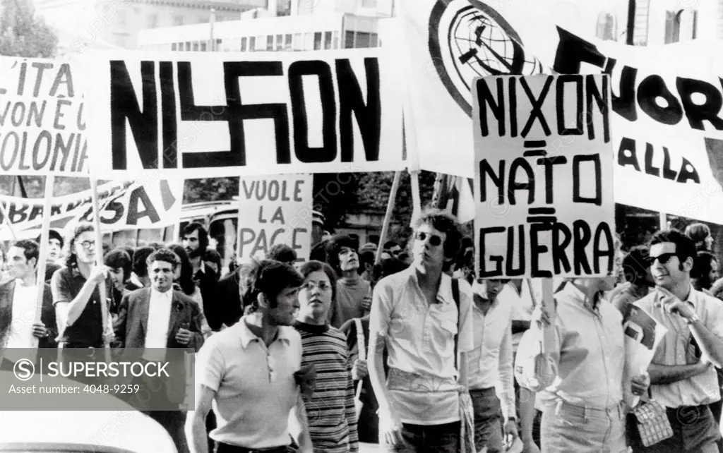 Italian anti-Nixon demonstrators march in anticipation of President Richard Nixon's visit. One of the signs displayed spelled Nixon with a swastika replacing the 'x'. Sept. 26, 1970.