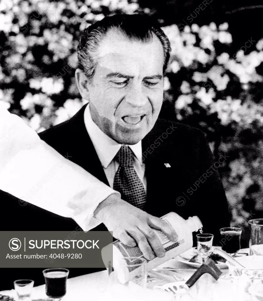 President Richard Nixon at a Chinese banquet. He watches as his glass is re-filled with Mao-tai, the potent alcoholic beverage used for the numerous toasts. Feb. 27, 1972.