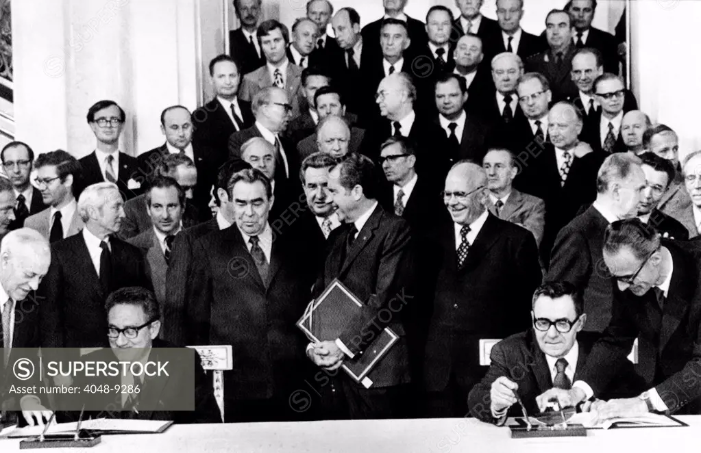 Secretary of State Henry Kissinger (seated left) and Soviet Foreign Minister Andrei Gromyko sign an scientific agreement at the Kremlin. In the center are Soviet Communist Party chief Leonid Brezhnev and President Nixon. Right of Nixon is Soviet President, Nikolai Podgorney. June 28, 1974.