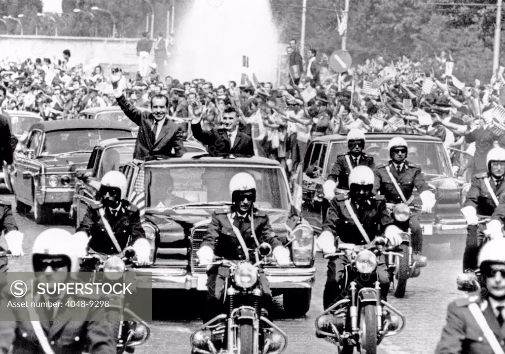 President Richard Nixon and President Nicolae Ceausescu wave to huge, flag-waving crowd during motorcade in Bucharest, Romania. August 2, 1969