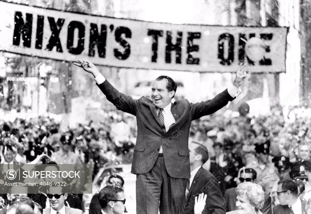 Richard Nixon, delivering his the 'V' for victory sign. An estimated 300,000 lined Philadelphia streets to watch his noon-hour motorcade. Large banner reads, 'Nixon's the One'. Sept. 20, 1968.