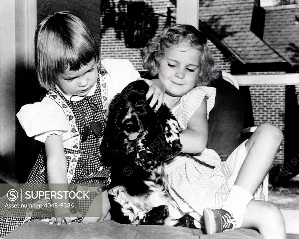 Julie and Tricia Nixon playing with their cocker spaniel, Checkers. The dog was mentioned by Richard Nixon in his dramatic television appearance, defending himself against accepting $ 18,000 in gifts. Sept. 24, 1952.