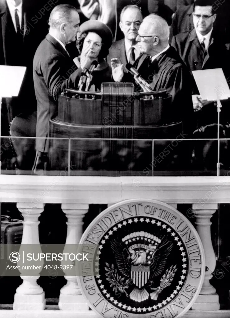 President Johnson takes the oath of office at his 1964 Inauguration. L-R: President and Mrs. Johnson, Vice President Hubert Humphrey, and Chief Justice Earl Warren. Jan. 20, 1964.