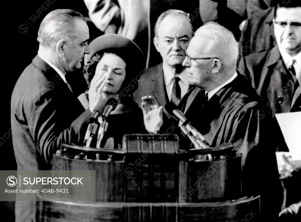 President Lyndon Johnson takes the oath of office at his 1964 Inauguration. L-R: President and Lady Bird Johnson, Vice President Hubert Humphrey, and Chief Justice Earl Warren. Jan. 20, 1965.