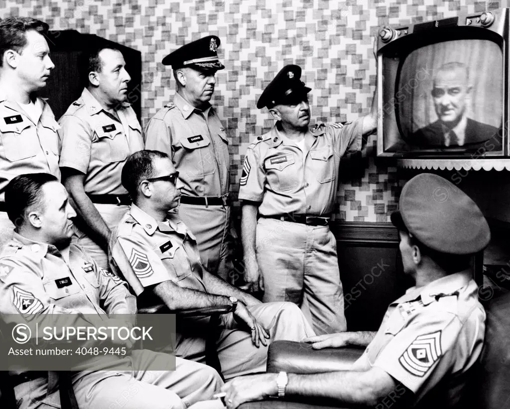 Military men at New York's 71st Street Armory watch President Lyndon Johnson's address on the US build-up in Vietnam. July 28, 1965.