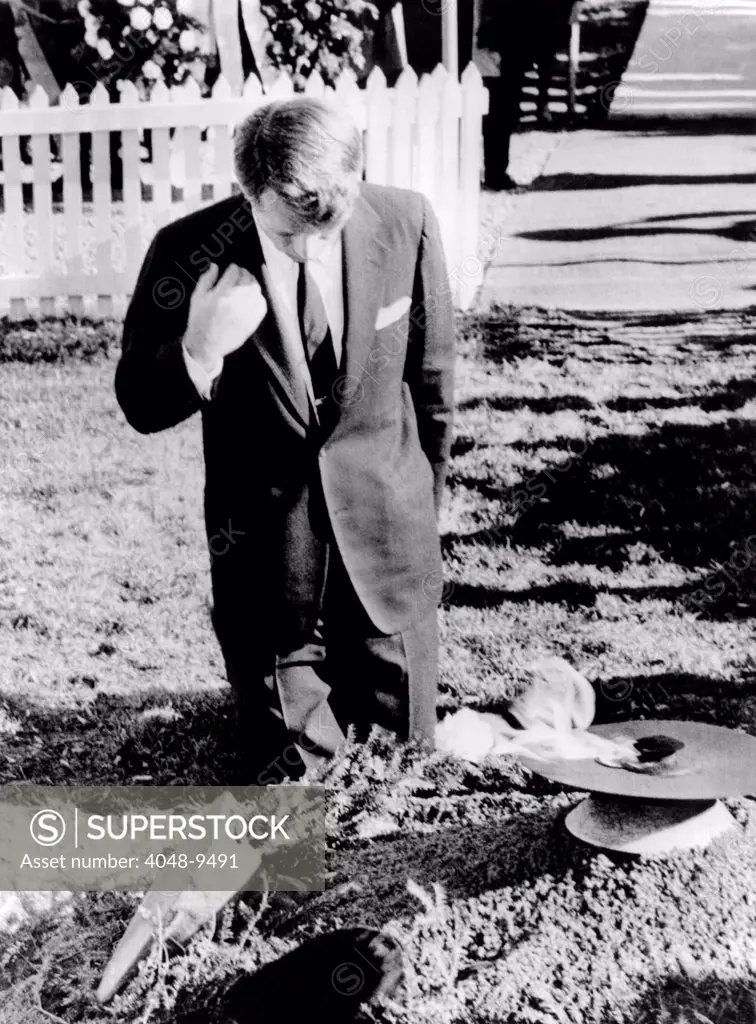 Robert Kennedy prays at his brother's grave. On the first anniversary of the John Kennedy assassination, the new Senator-elect attended a Memorial Mass at St. Matthew's Cathedral then visited the grave. Nov. 22, 1964.