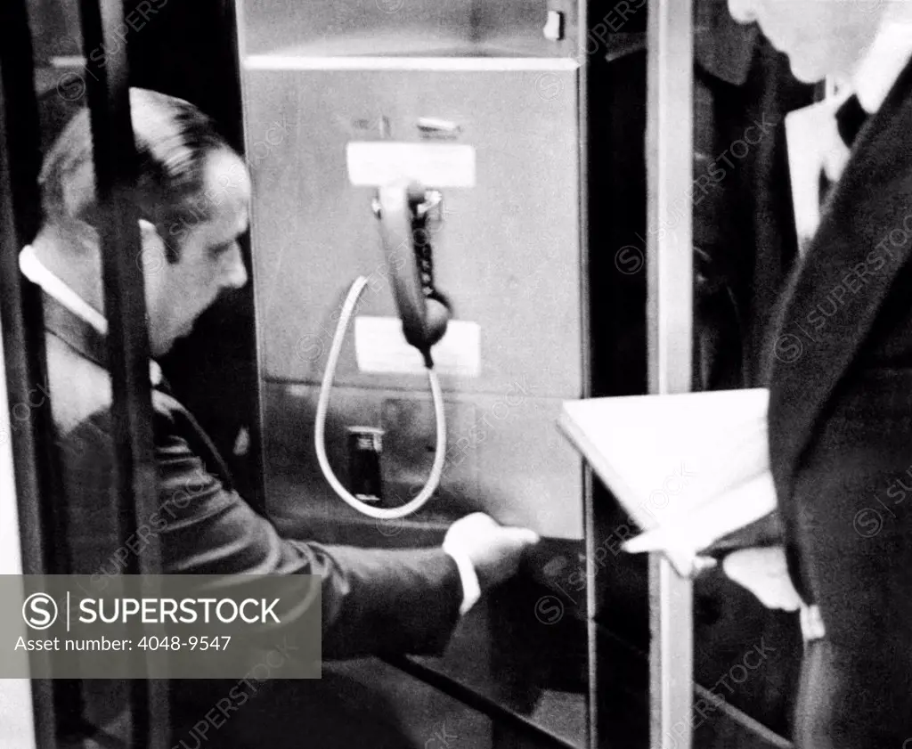 Anthony Ulasewicz, was a former New York City detective who worked as private investigator for the White House. Photo shows Ulasewicz taping a key to an airport public telephone to a locker containing money for Howard Hunt, one of the Watergate burglars. July 23, 1973.