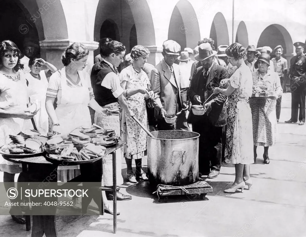 Breadline in Los Angeles serving soup and bread. The Spanish Colonial church, Neustra Senora La Reina de Los Angeles, feeds 700 unemployed on the patio of the old church. August 1931.