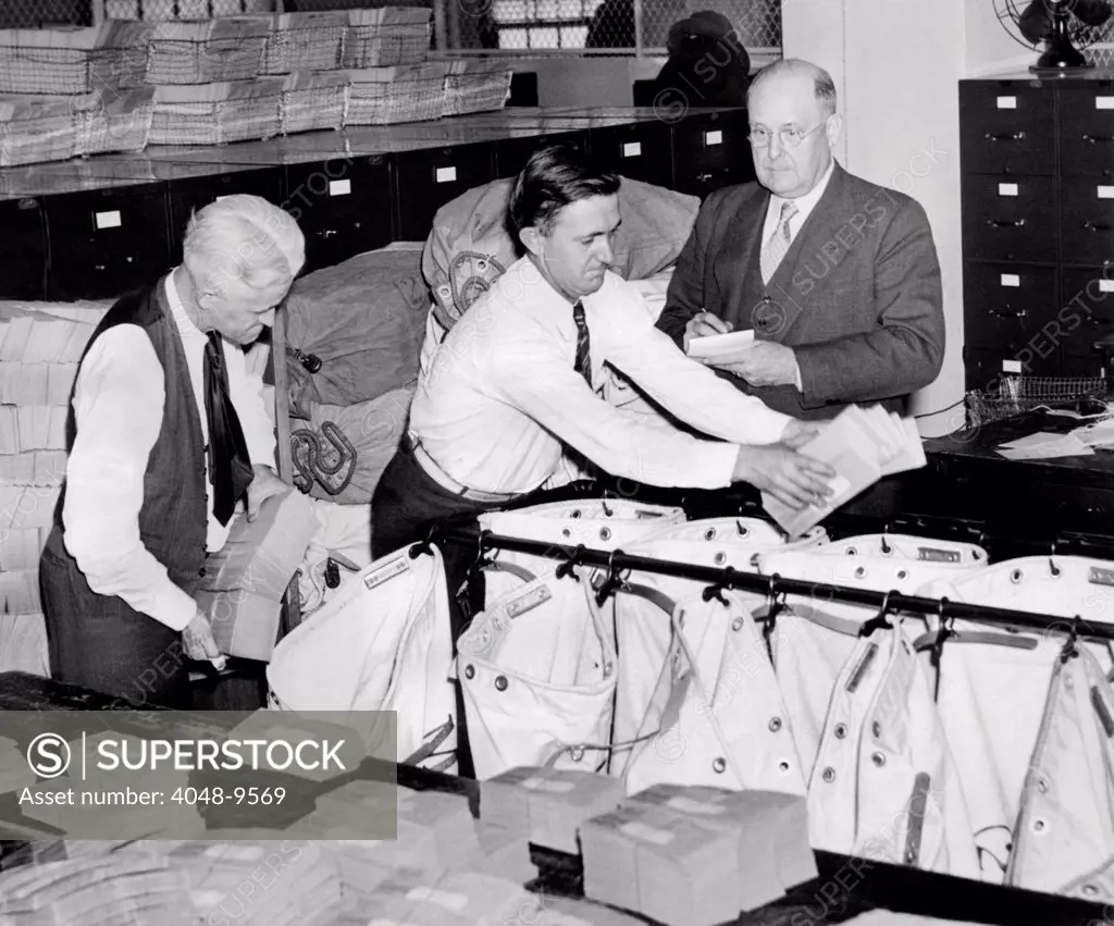 The first Social Security checks are mailed. Guy Allen, an officer of the Treasury Department (wearing jacket) supervises the mailing by the Post Office of thousands of old age insurance checks. Jan. 1, 1940.