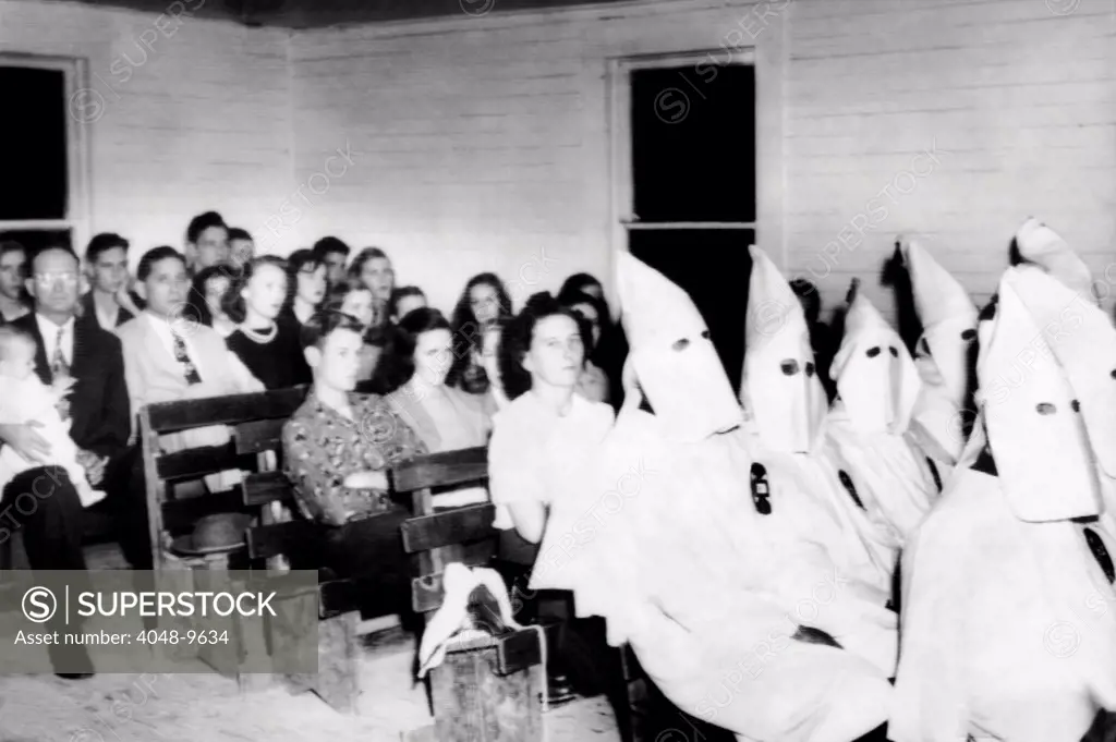75 Ku Klux Klansman joined the congregation of the Massay Line Church of God, located near Birmingham, Alabama. A Klan spokesman said the action was taken to intimidate patrons of a nearby beer joint who tried to 'disturb the peace', referring to desegregation. Nov. 24, 1948.