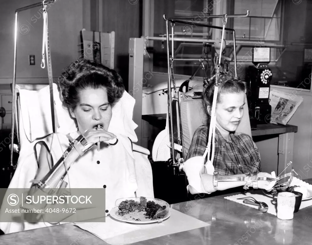 Two young women in rehabilitation after polio. They were both in Iron Lungs and are now feeding themselves with the help of special equipment. Rancho Los Amifos Respiratory Center in Hondo California. Dec. 27, 1954.