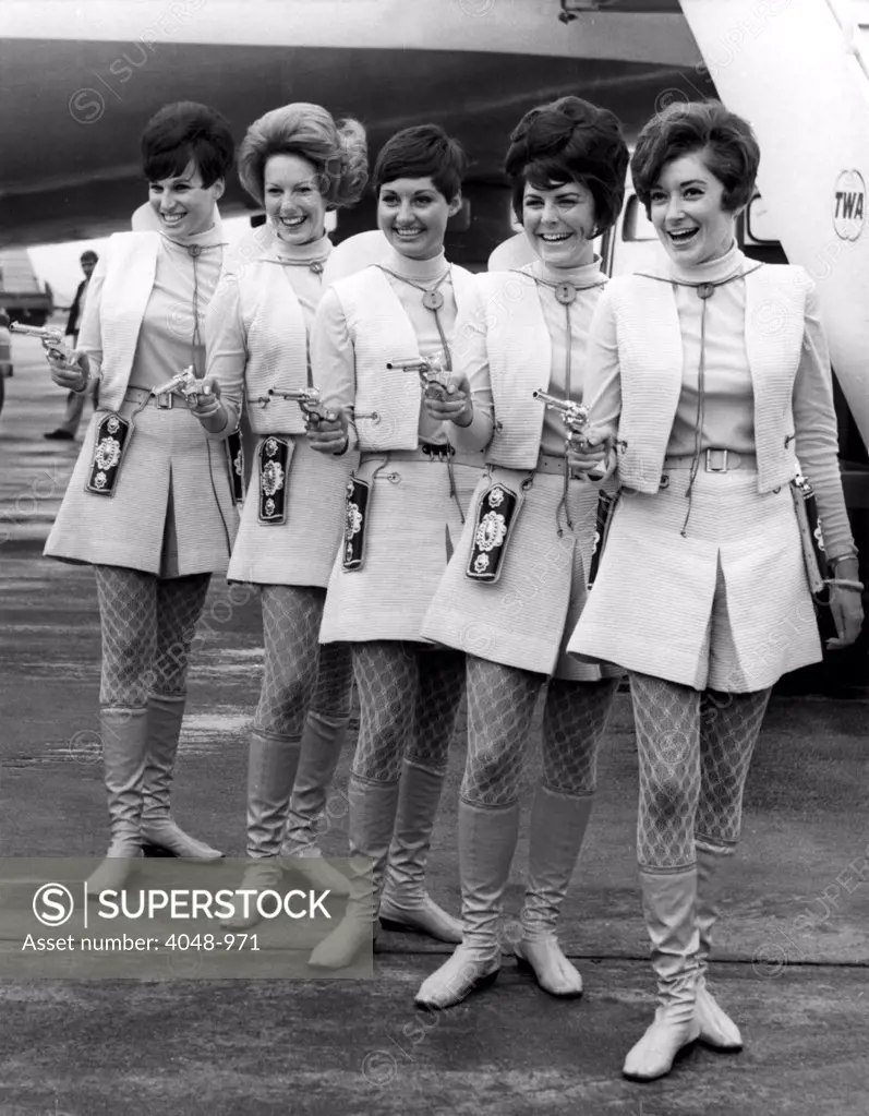 LONDON: These Western Air Lines hostesses are packing pisotls for a reason. They are not trying to keep visitors out of the country but are here to encourage tourists to visit the United States. April 29, 1968.