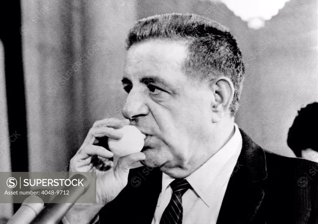 Joseph Valachi sucking a lemon juice container during Senate Investigations Subcommittee. The juice eased his hoarseness from continuous testimony. Oct. 2, 1963.