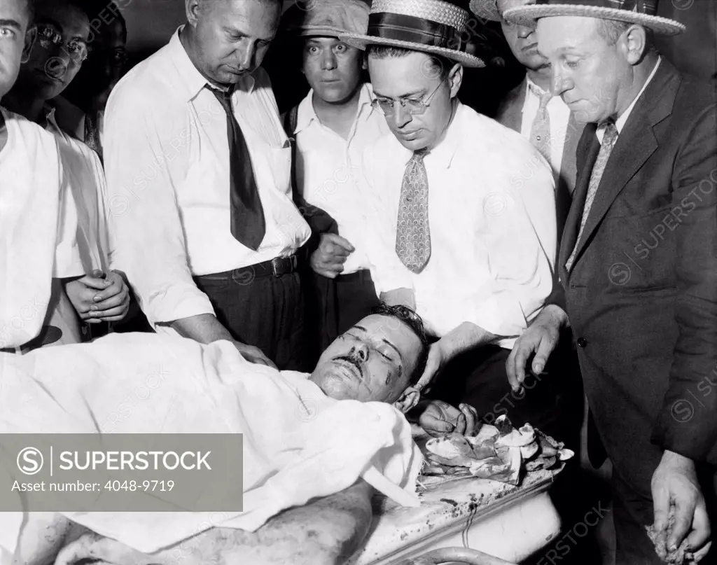 John Dillinger, Public Enemy No.1, lying on a slab in the county morgue in Chicago. Surrounded by policemen and coroner's assistants, he was killed outside a Chicago movie theater by FBI agents and police on July 23, 1934.
