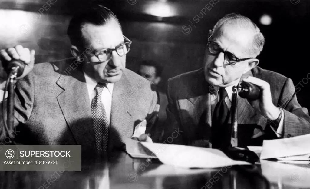 Frank Costello during Kefauver Committee hearings in NYC. Costello (left) and his attorney, George Wolf, hold hands over microphones during the Mafia boss's testimony on March 14, 1951.