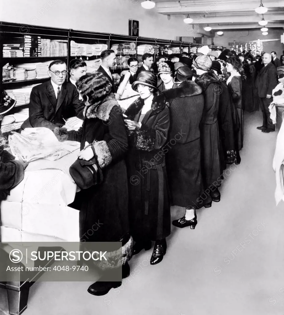 Women eagerly shop across the counter at a newly opened Sears retail store. The First Sears Retail stores opened in 1925 in Chicago.