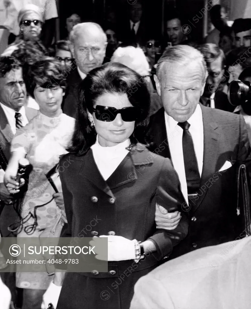 Jacqueline Kennedy leaving New York for Los Angeles for the bedside of Senator Robert Kennedy. The Senator was critically wounded by an assassin's bullets hours earlier. She is accompanied by very close friend, Roswell Gilpatric. June 6, 1968.