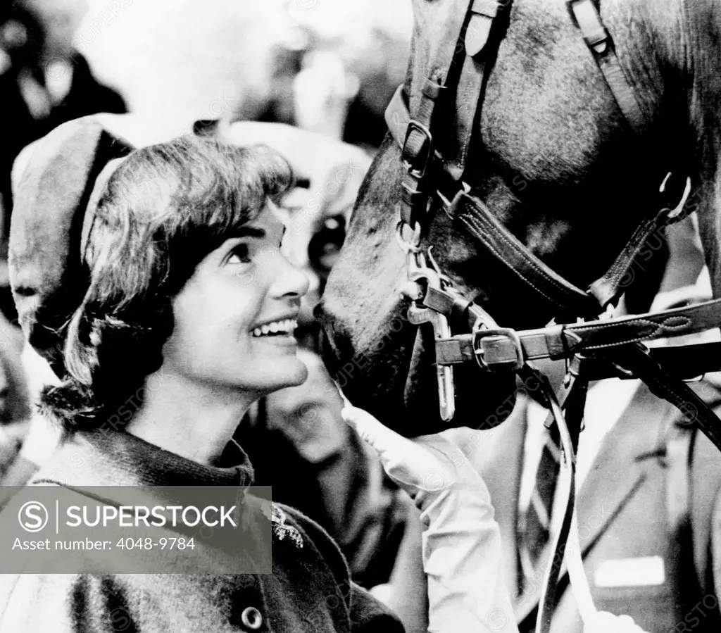 Jacqueline Kennedy beams at one of the famed horses of the Canadian Royal Mounted Police. She accompanied her husband, President John Kennedy, on a visit to Canada. May 17, 1961