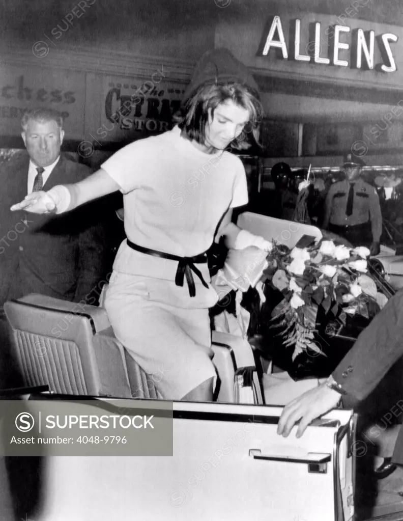 Jacqueline Kennedy balances gracefully as she exits a convertible on the day prior to President John Kennedy's assassination. Nov. 11, 1963.