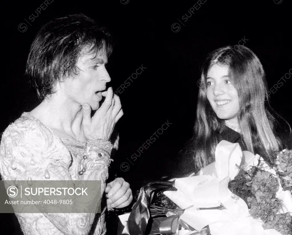 Ballet star Rudolph Nureyev treats a small cut on his finger caused by a thorn on the roses held by Caroline Kennedy. The daughter of the late President visited the dancer after his performance with the Australian Ballet. Jan. 28, 1971.